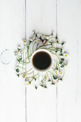 cup of coffee surronded by flowers