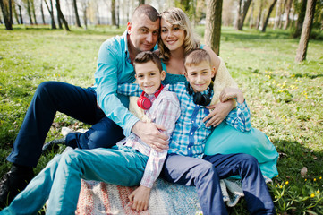 Happy pregnant family with two sons, dressed in a turquoise clot