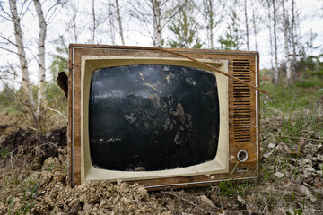 Old analog discarded television set in the forest