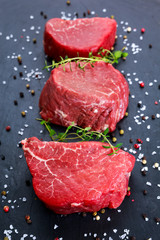 Fresh Raw Beef steak Mignon, with salt, peppercorns, thyme, garlic.