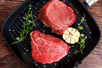 Fresh Raw Beef steak Mignon, with salt, peppercorns, thyme, garlic.