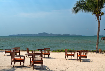 Tables on the beach with palm tree