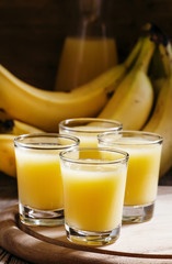 Banana juice and fresh bananas, vintage wooden background, selec