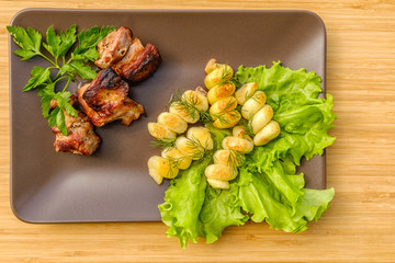 Grilled meat. Parsley dill. On a plate of ceramics.