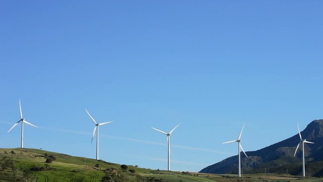 Wind turbines energy rotating in the mountain with blue sky