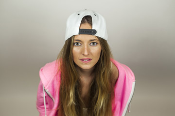 Close up portrait beautiful woman with pink sweatshirt and white cap shoot in studio, isolated on a white background