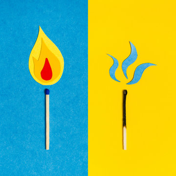 Two Safety Matches On Colorful Paper Background. Burning Match On Blue Background. Burnt Out Match On Yellow Background.