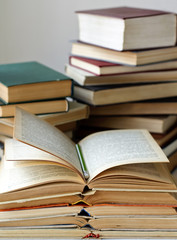 stacks of old closed and opened books and pencil. vertical