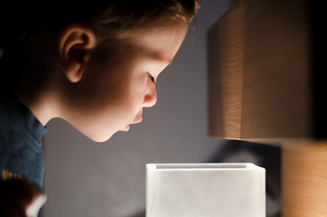 Small boy looking into lamp