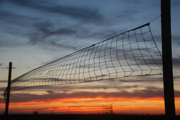 Volleyball net on sunset sky background