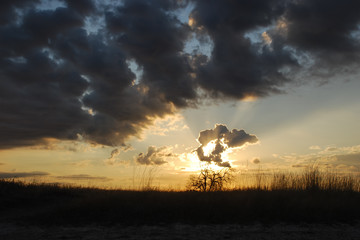 The sun's rays shine through the clouds