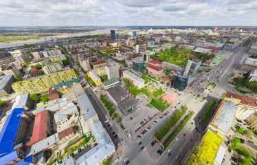 Fototapeta premium Aerial city view with crossroads and roads, houses, buildings, parks and parking lots, bridges. Copter shot. Panoramic image.