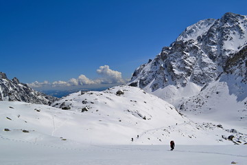 Fototapeta na wymiar Hiking trail in snow in mountains in a sunny day