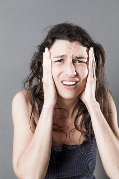 desperate young woman holding her face for stressful migraine