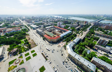 Aerial city view with crossroads and roads, houses, buildings, parks and parking lots, bridges. Copter shot. Panoramic image.