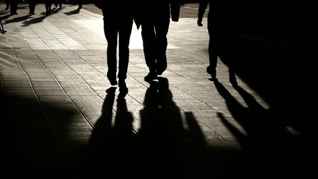 STOCKHOLM, SWEDEN, APR 2016: Three silhouette businessmen walking in wind with their shadows on the ground