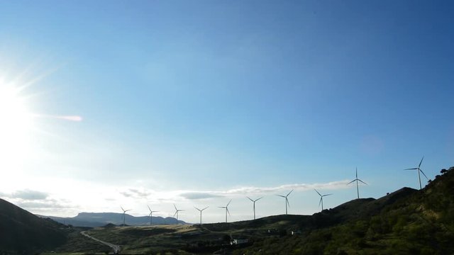 Wind turbines energy in the mountain at sunset backlit