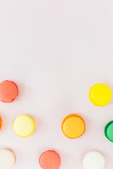 Sweet colorful French macaroon biscuits on pastel background, to