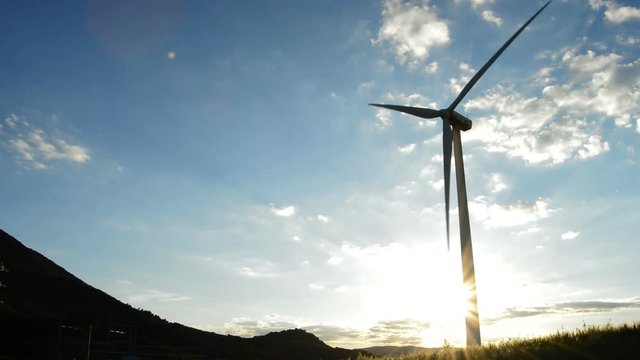 Wind turbine energy moving at sunset