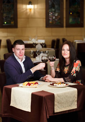 Couple toasting wineglasses in a luxury restaurant