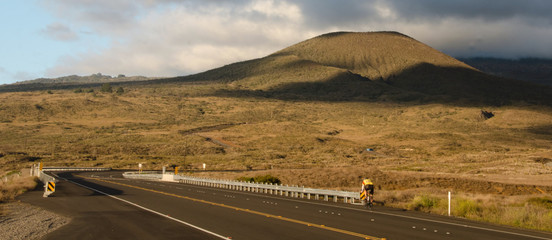 Bicyclist riding near sunset on route 200