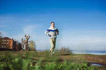 Young Slim Man Running on the Trail in park  Active Lifestyle