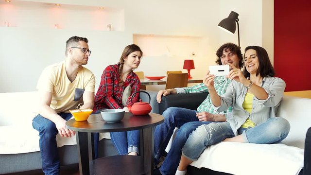 Friends sitting in the flat and having a videocall

