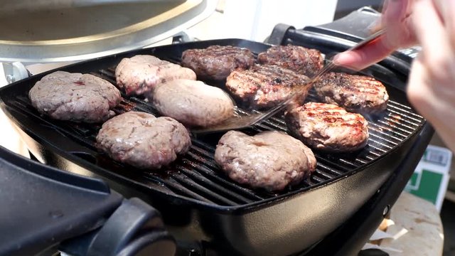 Burgers Being Turned Over While Grilled