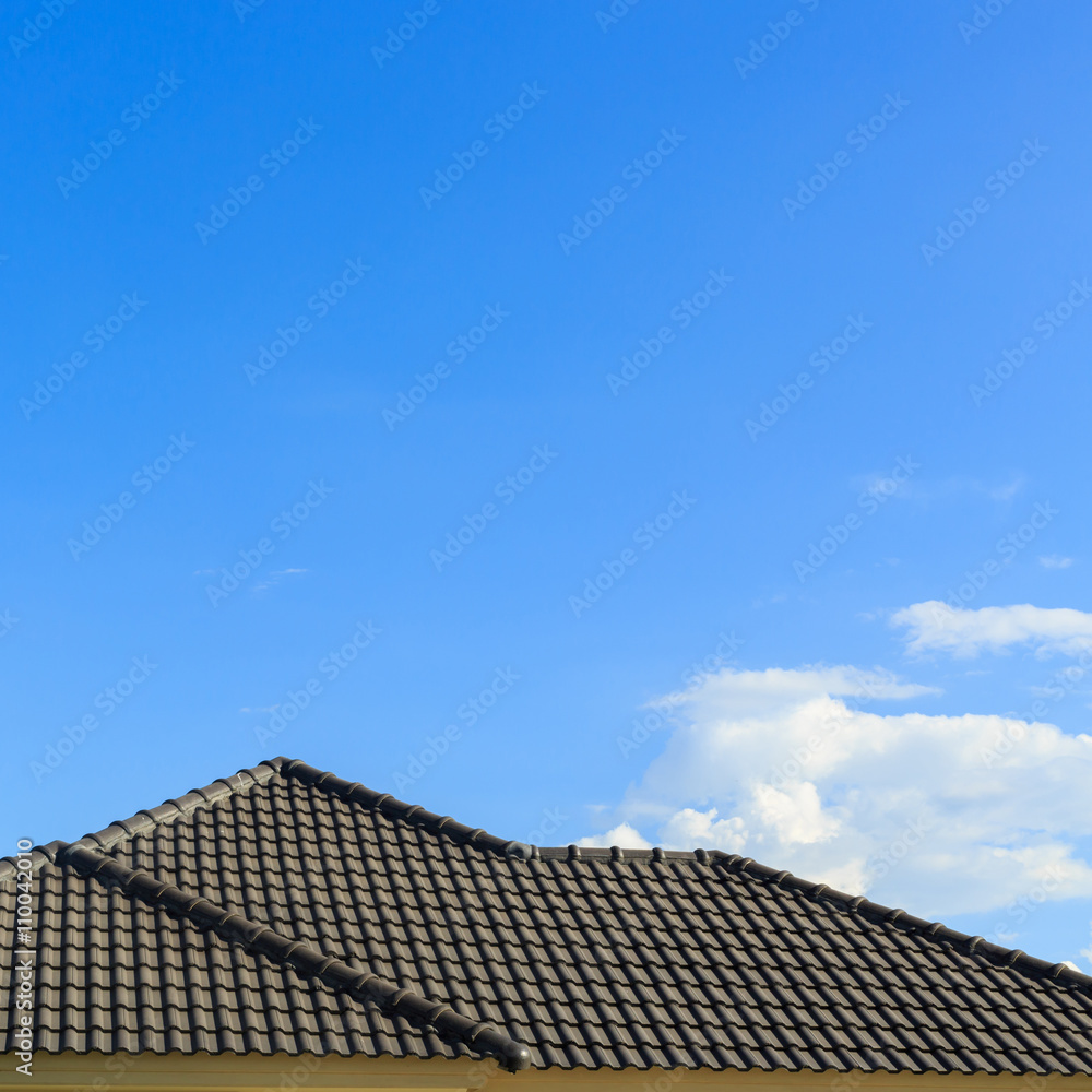 Wall mural black tile roof on a new house with clear blue sky background