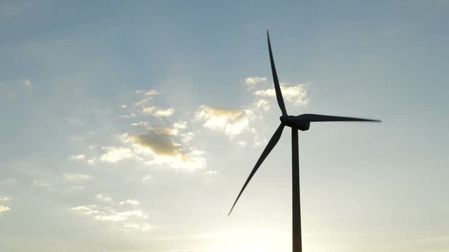 Wind turbine rotating at sunset at afternoon
