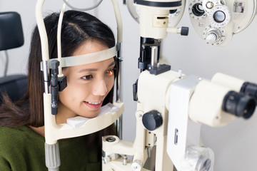 Woman doing the eye test inside optical clinic