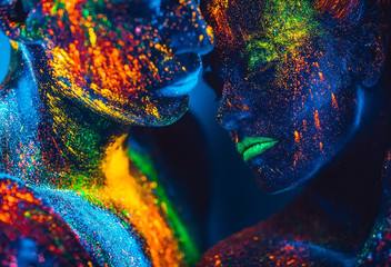 People are colored fluorescent powder. a pair of lovers dancing