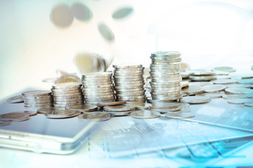 Coins stacked with falling moving on abstract  blur of mobile ph
