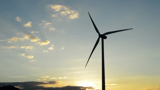 Wind turbine moving at sunset