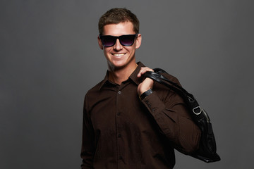 smiling man with a handbag. Handsome man in sunglasses