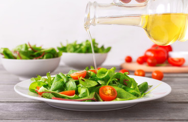 Olive oil pouring in the Italian salad