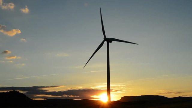 Wind turbine rotating at sunset at afternoon