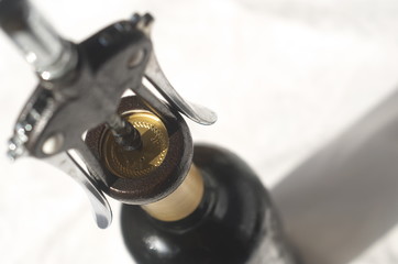 A bottle of wine and a  sommelier corkscrew