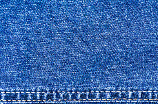Blue jeans material with stitched stripe track texture background close up