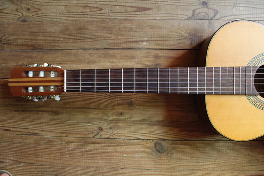 Acoustic guitar on the background of wood