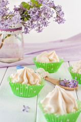 Fototapeta na wymiar Meringue cakes near lilac flowers