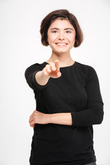 Smiling woman pointing finger at camera