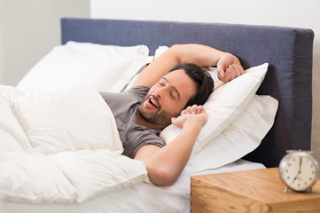 Man yawns in bed