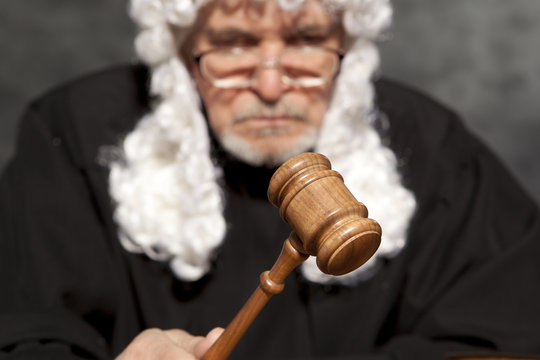 Old male judge in a courtroom striking the gavel