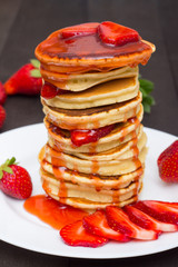 Fresh pancake stack with syrup streaks decorated with strawberries