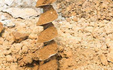 Drilling rig boring hole in soil at construction site