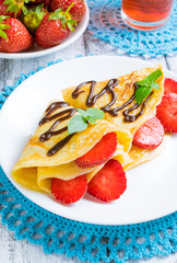 Pancakes with sliced strawberries and chocolate