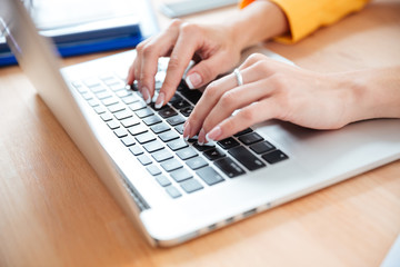 Female hands typing on the laptop computer in office