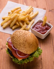 homemade hamburger on wooden table with fries