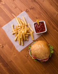 homemade hamburger on wooden table with fries